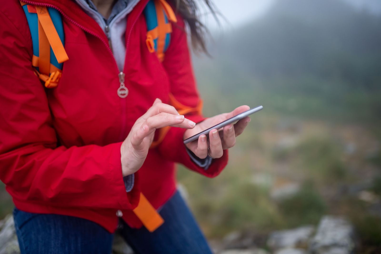 A phone showing a route map held up on the trail, path running ahead