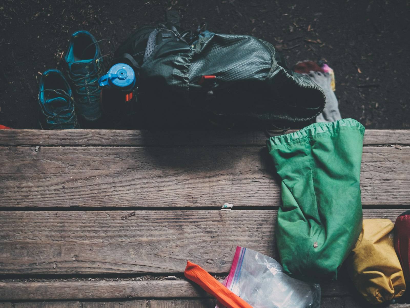 Small black day-pack with walking gear laid out beside it