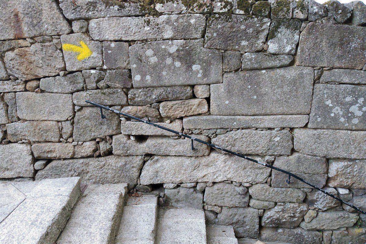 Yellow arrow waymark guiding pilgrims along the Camino Portugues