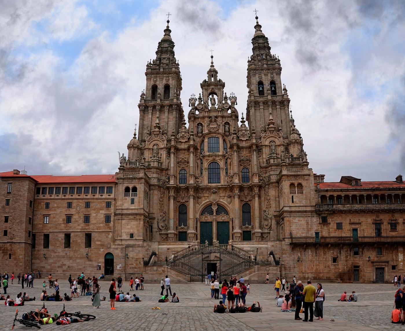 Wide view of people gathered on the plaza in front of Santiago de Compostela cathedral after arriving