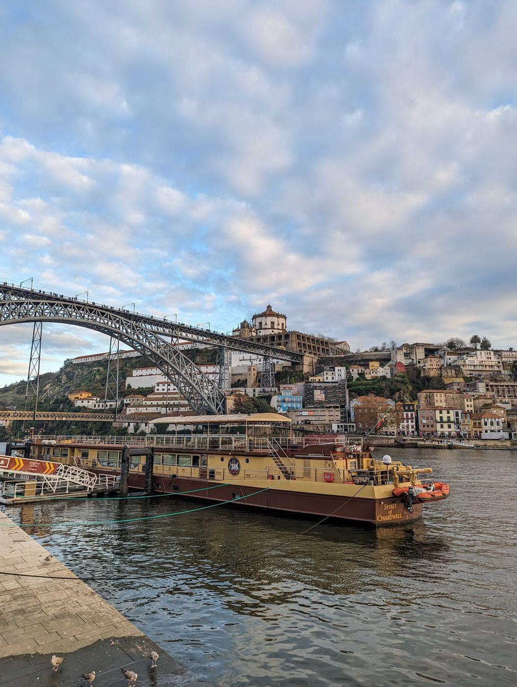 Panoramic view of Porto's Ribeira waterfront with the iron arch of the Dom Luís I bridge spanning the Douro river